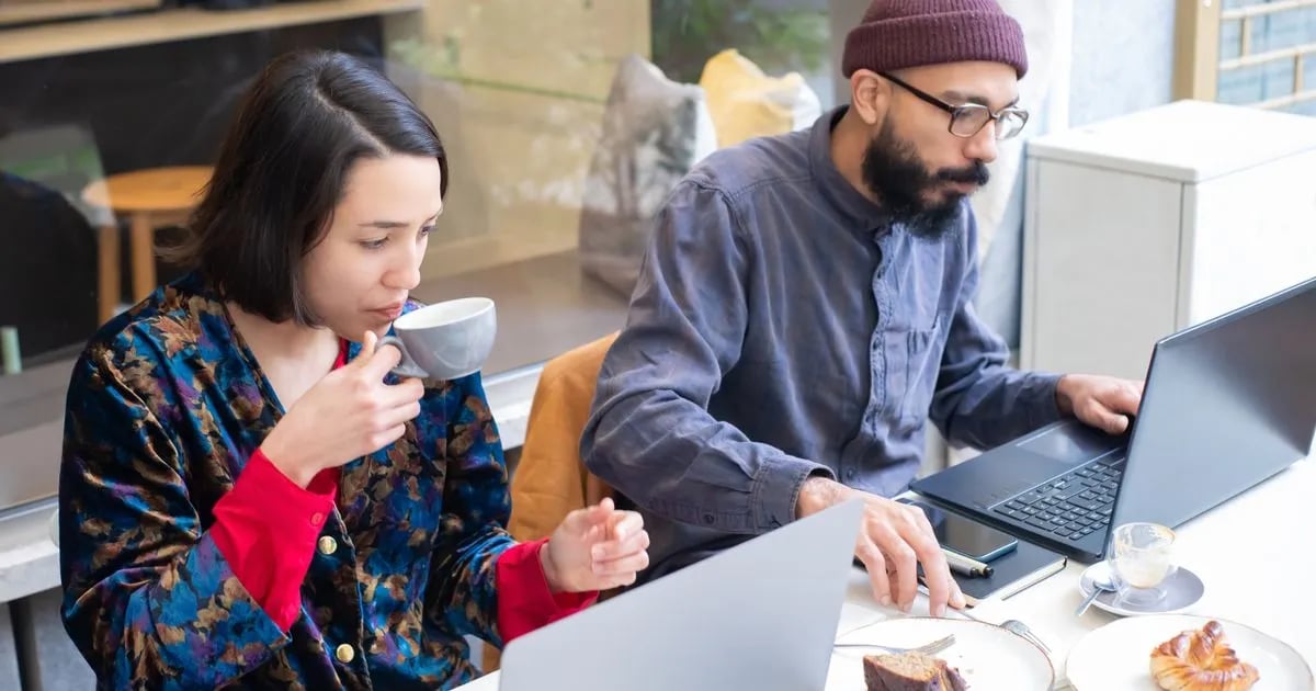 Freelancers working on laptops in a café